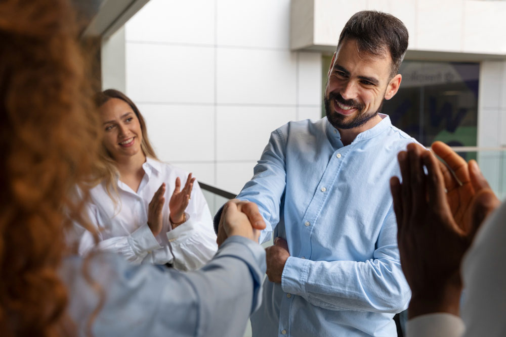 Hombre-siendo-aplaudido-por-sus-colegas con el Curso de Oratoria de CoachMe
