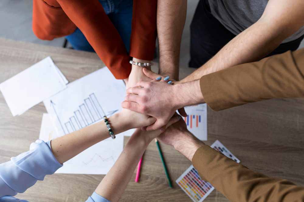 Grupo de personas uniendo sus manos en señal de trabajo en equipo
