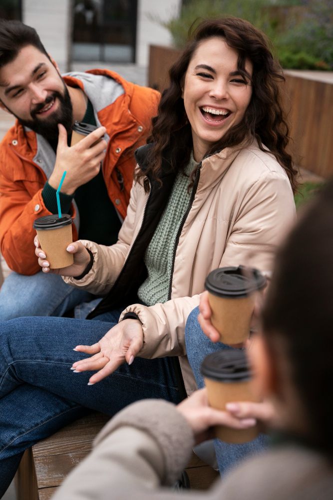 Grupo de amigos tomando café y charlando al aire libre